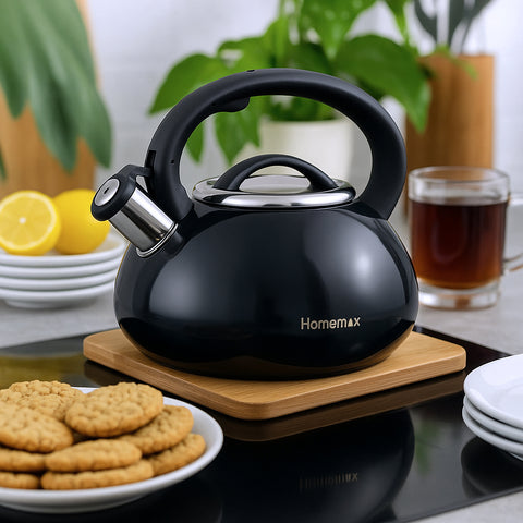 Black Homemax kettle on a wooden trivet with cookies and lemon slices in the background